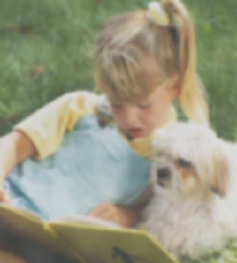 Fuzzy image of girl reading with her dog